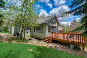 View of property exterior with cooling unit and a wooden deck