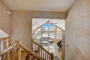 Hall with beamed ceiling, hardwood / wood-style flooring, and high vaulted ceiling