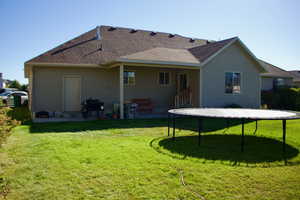 Rear view of house featuring a yard and a patio area