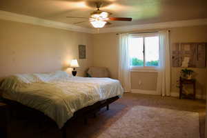 Bedroom featuring ceiling fan, light colored carpet, and crown molding