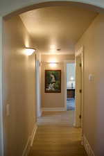 Corridor with a textured ceiling and light hardwood / wood-style floors