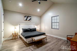 Bedroom with high vaulted ceiling, ceiling fan, and hardwood / wood-style floors