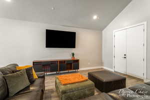 Living room with light hardwood / wood-style flooring and high vaulted ceiling