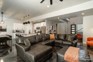 Living room featuring ceiling fan and sink