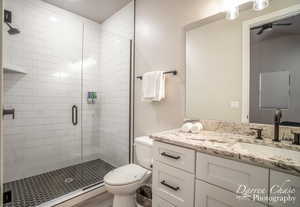 Bathroom featuring wood-type flooring, vanity, toilet, and an enclosed shower