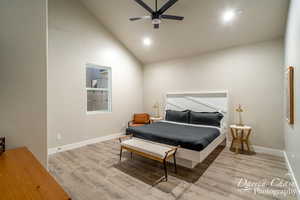 Bedroom featuring high vaulted ceiling, light hardwood / wood-style floors, and ceiling fan