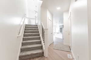 Stairs featuring ceiling fan, wood-type flooring, and sink