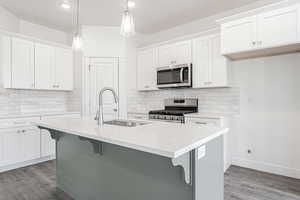 Kitchen featuring white cabinetry, appliances with stainless steel finishes, and sink