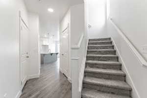 Stairs featuring sink and hardwood / wood-style floors