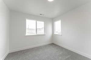 Carpeted empty room featuring a textured ceiling