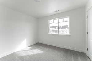 Carpeted empty room with a textured ceiling