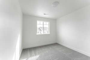 Spare room featuring carpet floors and a textured ceiling