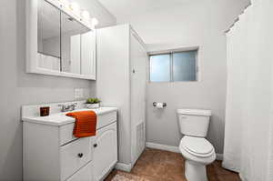 Bathroom featuring vanity, toilet, and tile patterned floors