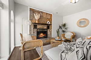 Living room with hardwood / wood-style flooring and a stone fireplace