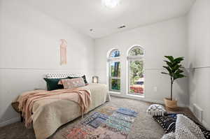 Carpeted bedroom featuring vaulted ceiling