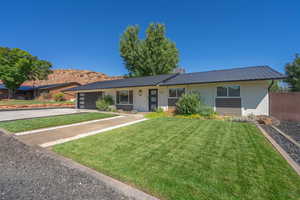 Single story home with a garage and a front lawn