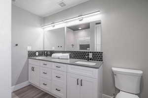 Bathroom with backsplash, vanity, and toilet