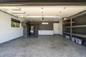 Garage featuring a garage door opener, sink, and a wall unit AC