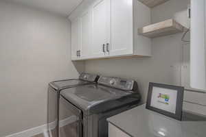 Washroom with cabinets, hardwood / wood-style floors, and independent washer and dryer