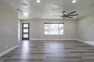 Interior space with ceiling fan and dark hardwood / wood-style floors