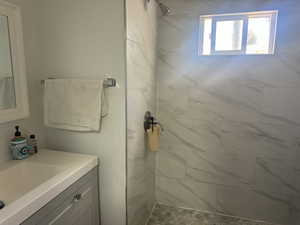 Bathroom with vanity and tiled shower