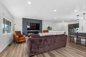 Living room featuring light wood-type flooring, plenty of natural light, and wood walls