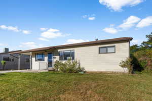 Rear view of house with central air condition unit and a yard