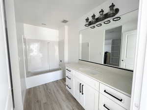 Bathroom featuring vanity, hardwood / wood-style flooring, and bathing tub / shower combination