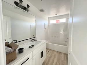 Bathroom with vanity, hardwood / wood-style floors, and shower / bathing tub combination