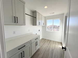 Laundry room featuring cabinets, light hardwood / wood-style flooring, and electric dryer hookup