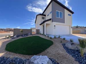 View of front of property featuring a garage and a front yard