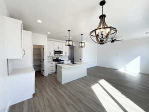 Kitchen with pendant lighting, sink, white cabinets, a kitchen island with sink, and stainless steel appliances