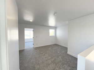 Carpeted empty room featuring a textured ceiling