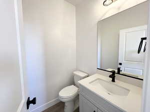 Bathroom with vanity, wood-type flooring, and toilet