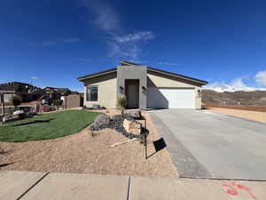 View of front facade featuring a garage, a mountain view, and a front yard