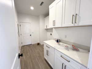 Washroom featuring cabinets, light hardwood / wood-style floors, and hookup for a washing machine