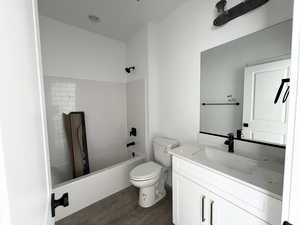 Full bathroom featuring vanity, wood-type flooring, toilet, and washtub / shower combination