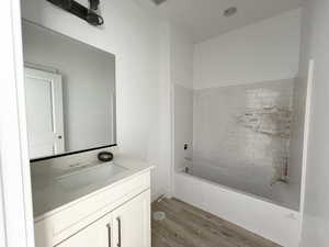 Bathroom with vanity, hardwood / wood-style flooring, and tiled shower / bath combo