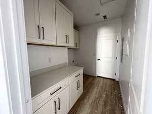 Kitchen with dark hardwood / wood-style floors and white cabinets