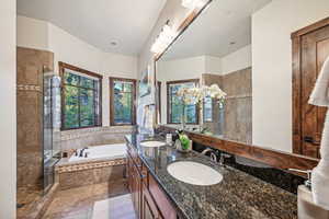 Bathroom with tile patterned floors, vanity, and separate shower and tub