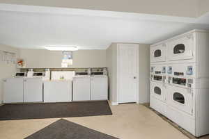 Laundry room with stacked washing maching and dryer and independent washer and dryer