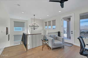 Sitting room featuring light hardwood / wood-style flooring and ceiling fan with notable chandelier