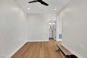 Unfurnished bedroom featuring ceiling fan, connected bathroom, and light hardwood / wood-style floors