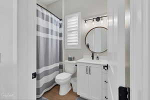 Bathroom with vanity, toilet, and hardwood / wood-style flooring