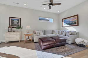 Living room featuring dark wood-type flooring and ceiling fan