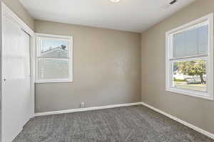 Empty room featuring a wealth of natural light and carpet