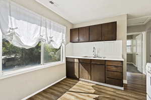 Kitchen featuring hardwood / wood-style floors, dark brown cabinets, electric stove, and sink