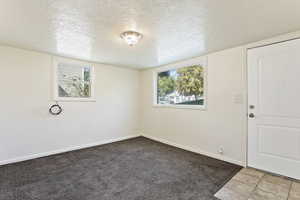 Carpeted empty room with a wealth of natural light and a textured ceiling