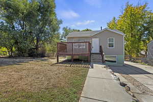 View of front of property featuring a patio area, a front yard, and a deck