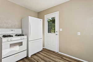 Kitchen with hardwood / wood-style floors and white appliances